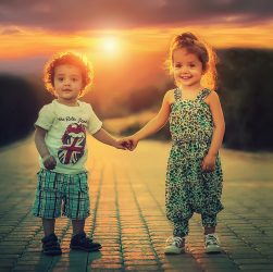 Dzieci trzymają się za ręce przy zachodzie słońca